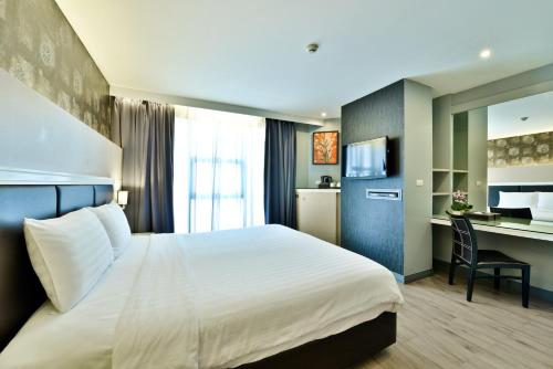 una camera d'albergo con letto e scrivania di Prestige Suites Nana a Bangkok