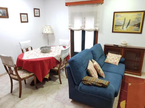 a living room with a blue couch and a table at Virginia Redondela in Redondela