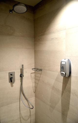 a bathroom with a shower with a soap dispenser on the wall at Best Western Plus Soave Hotel in San Bonifacio