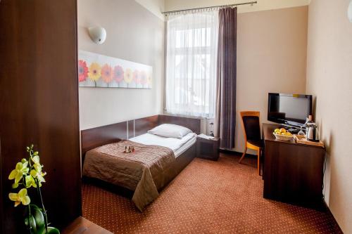 a hotel room with a bed and a television at Hotel Diament Economy Gliwice in Gliwice