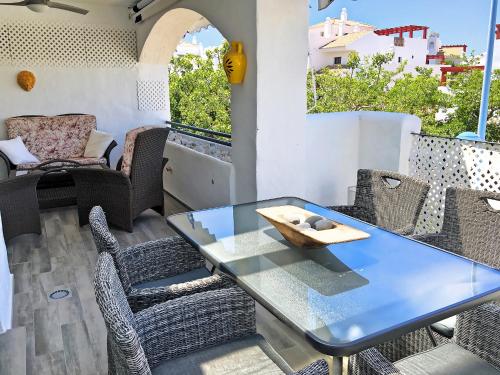 una mesa de cristal y sillas en un patio con mesa en Apartment La Mesana by Interhome, en Marbella