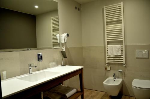a bathroom with a sink and a toilet and a mirror at Best Western Plus Soave Hotel in San Bonifacio