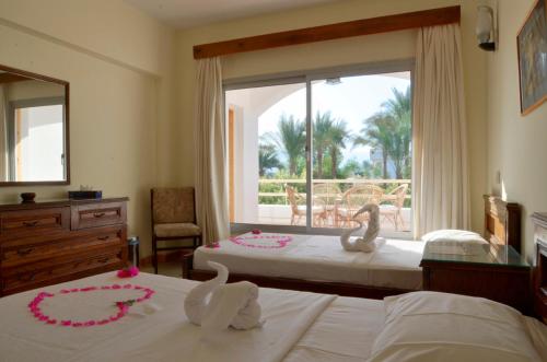 a bedroom with two beds with pink flowers on them at Oonas Dive Club in Sharm El Sheikh