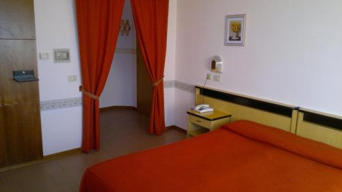 a room with a bed and red curtains at Hotel Centrale in Argenta
