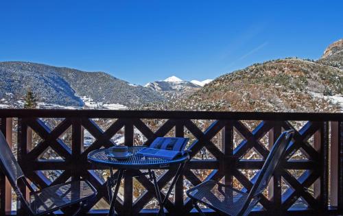 a blue table and chairs on a balcony with mountains at Apartaments Giberga in LʼAldosa