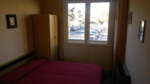 a bedroom with a bed and a window with a street at Hotel Centrale in Argenta