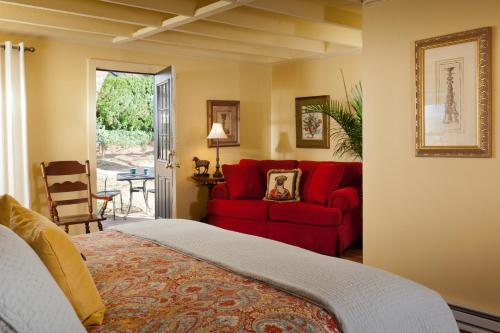 a bedroom with a red bed and a red couch at The Inn & Tavern at Meander in Locust Dale