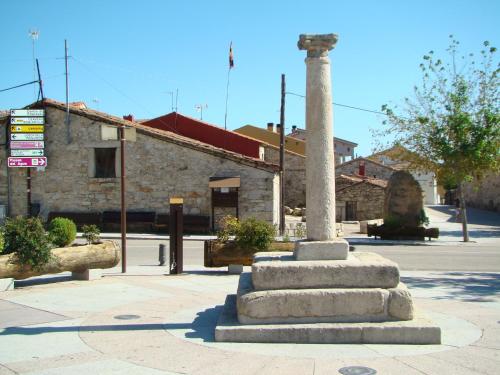 a pillar in the middle of a street in front of a building at Alojamientos El Castillo in El Berrueco