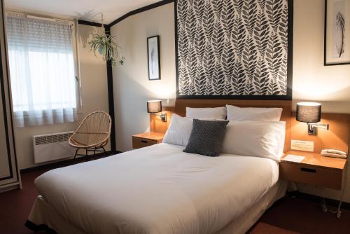 a bedroom with a large white bed and a window at Hotel de Jouvence in Dax
