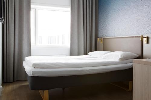 a bedroom with two beds in front of a window at Comfort Hotel Xpress Tromsø in Tromsø
