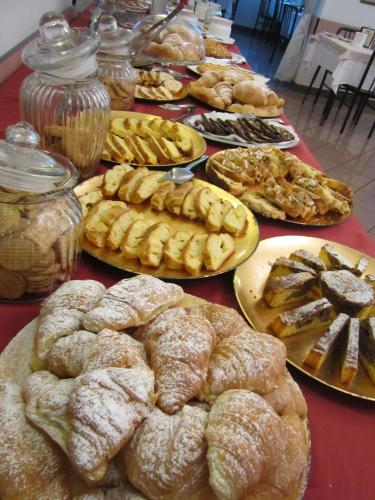 une table remplie de différents types de pâtisseries sur les assiettes dans l'établissement Hotel Des Bains, à Cattolica