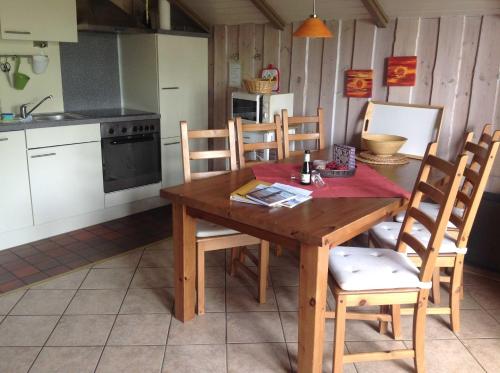 a kitchen with a wooden table and some chairs at Ferienwohnung Michel in Glücksburg