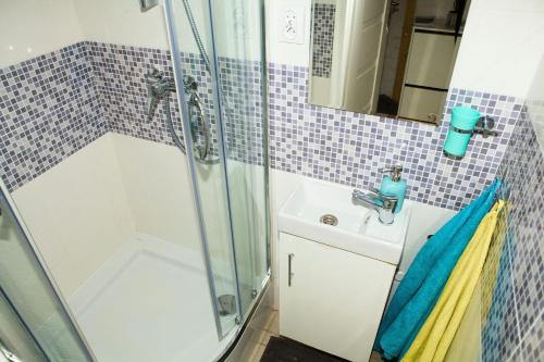 ein Bad mit einer Dusche und einem Waschbecken in der Unterkunft Apartament Żelazna in Warschau