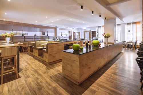 a large kitchen and dining room with tables and chairs at Hotel Goll Pforzheim-Niefern in Niefern-Öschelbronn