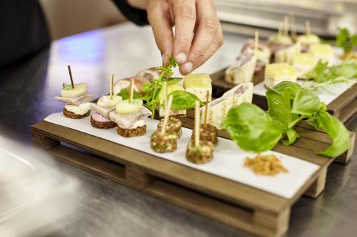 a person is serving food on a table at Hotel Goll Pforzheim-Niefern in Niefern-Öschelbronn
