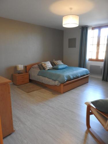 - une chambre avec un lit doté de draps bleus et une table de nuit dans l'établissement Les Petits Cléments, à Villars