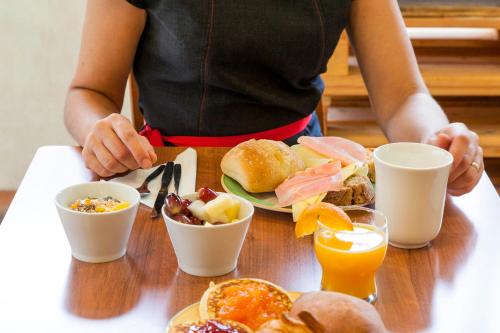a person sitting at a table with a plate of breakfast food at Hotel ibis Lisboa Liberdade in Lisbon