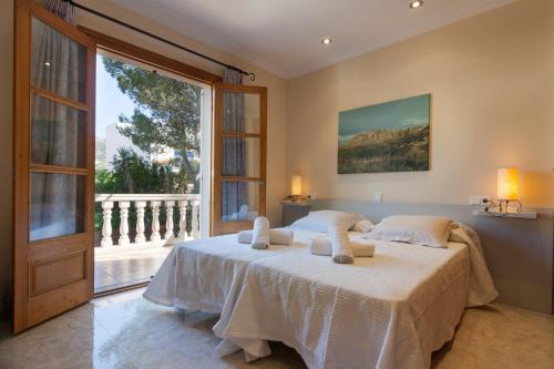 ein Schlafzimmer mit einem Bett und einem großen Fenster in der Unterkunft Montferrutx in Colònia de Sant Pere