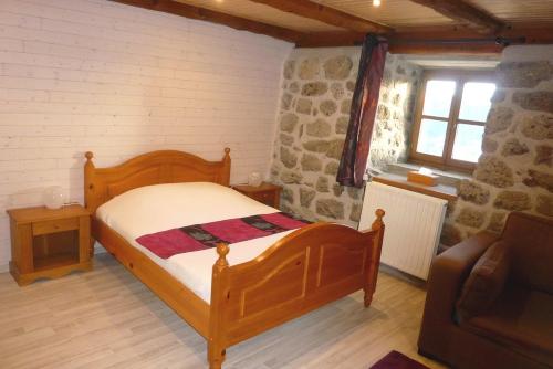 a bedroom with a bed and a couch and a window at La Bergerie du Plateau in Cros-de-Géorand