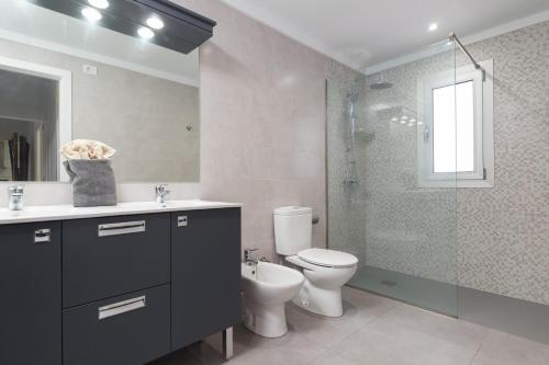 a bathroom with a toilet and a glass shower at Verdera in Playa de Muro