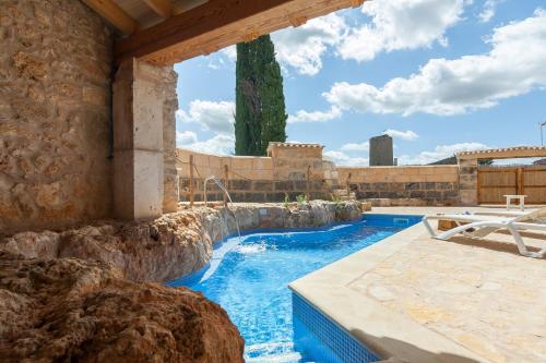 a swimming pool with a waterfall in a stone building at Ca Nostra in Algaida