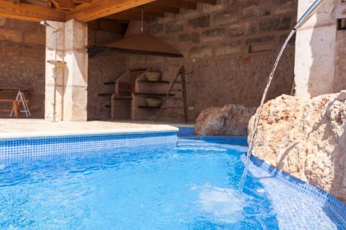 an indoor swimming pool with a water fountain at Ca Nostra in Algaida