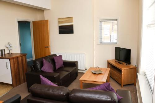 a living room with a couch and a television at Parks Nest 5 in Hull