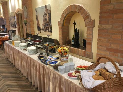 a buffet table with food on it in a building at Kastélykert Fogadó in Szeged