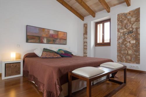 a bedroom with a bed and a table and a window at Casa Puça in Sa Pobla