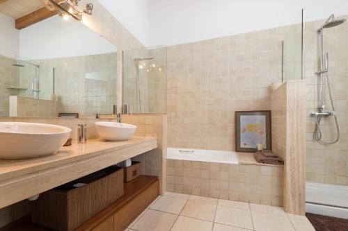 a bathroom with two sinks and a shower and a tub at Casa Puça in Sa Pobla