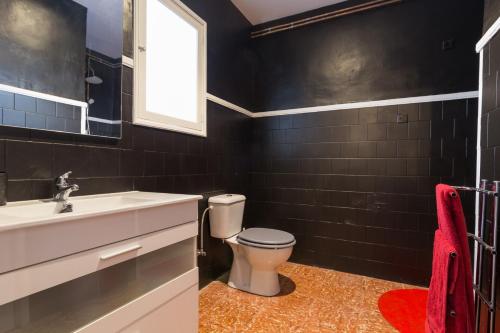 a bathroom with a toilet and a sink and a window at La Penya in Sa Pobla