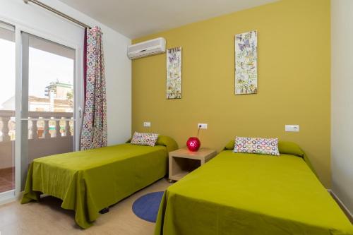 um quarto com 2 camas e uma varanda em Jeronimo em Playa de Muro