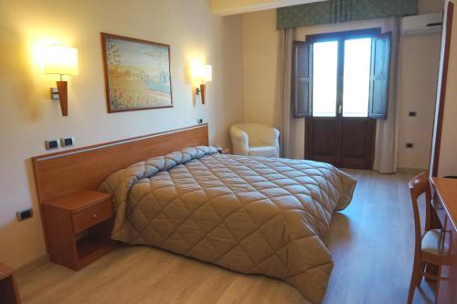 a bedroom with a bed and a desk and a window at Bel Sito Hotel Due Torri in Manocalzati