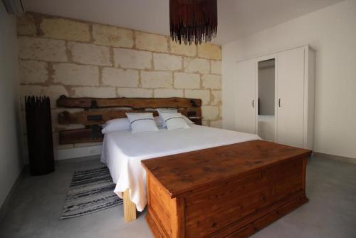 a bedroom with a large bed and a stone wall at Casa Mercat in Sa Pobla