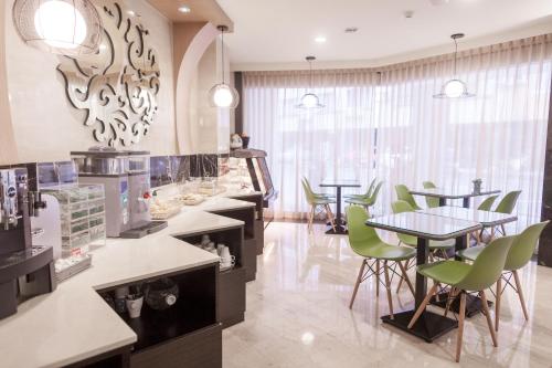a restaurant with tables and green chairs in a room at Maple Hotel in Tainan