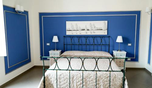 a bedroom with a blue wall and a bed at B&B San Trifone in Adelfia