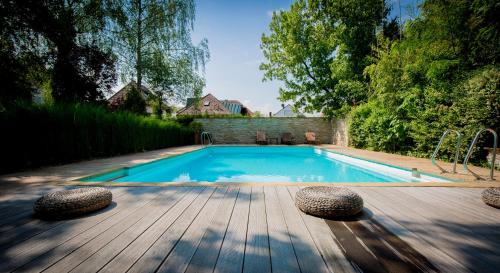 - une piscine sur une terrasse en bois à côté d'une maison dans l'établissement Kurhotel Markushof, à Bad Bellingen