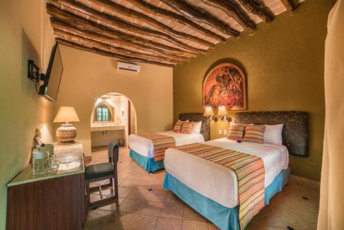 een slaapkamer met 2 bedden in een kamer bij Hotel Posada del Hidalgo - Centro Histórico a Balderrama Collection Hotel in El Fuerte