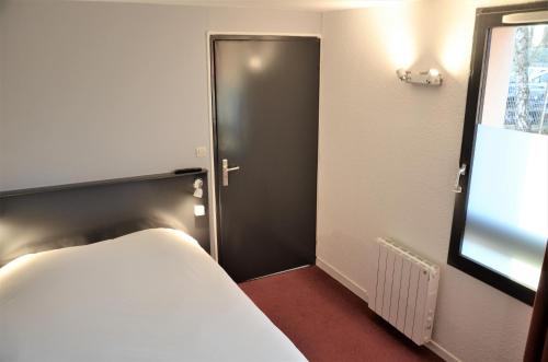 a room with a bed and a black door at The Originals City, Hôtel Amys, Tarbes Sud in Odos