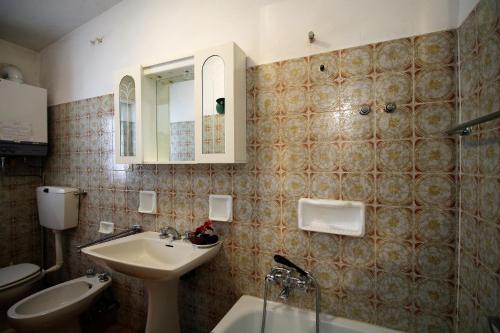 a bathroom with a sink and a toilet and a mirror at Casa Soleil by Holiday World in Limone Piemonte