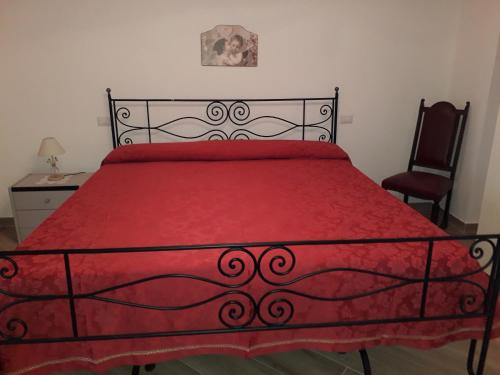 a bedroom with a red bed with a red bedspread at Casa Vacanza Campoli in Ruffano