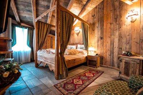 1 dormitorio con 1 cama en una habitación con paredes de madera en Hotel Jolanda Sport, en Gressoney-la-Trinité