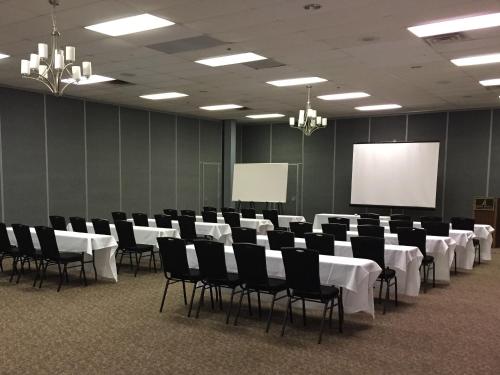 a conference room with white tables and chairs and a screen at Hope Hotel and Richard C. Holbrooke Conference Center in Fairborn