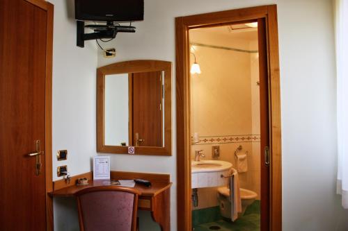 a bathroom with a sink and a toilet and a mirror at Hotel Savoia Sorrento in Sorrento