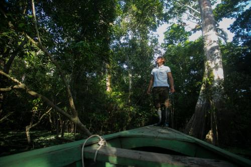 a man standing on top of a bridge in the forest at Ämak Iquitos Ecolodge - All Inclusive in Santa Clara