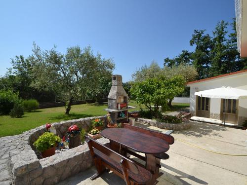 a wooden bench sitting next to a stone wall at Apartment Dada-2 by Interhome in Omišalj