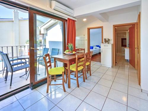 a dining room with a table and chairs and a balcony at Apartment Damir-3 by Interhome in Crikvenica