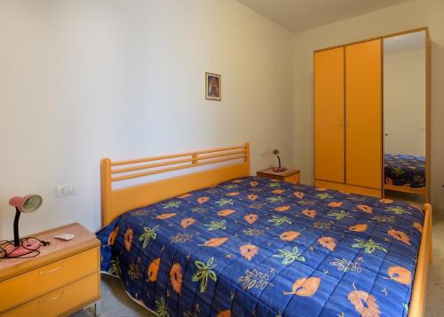 a bedroom with a bed with a blue comforter at Appartamenti Il Gabbiano in Lampedusa