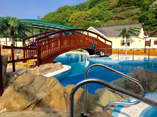 a bridge over a swimming pool in a resort at Cardigan Bay Holiday Park in Cardigan