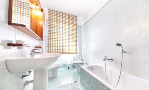 La salle de bains est pourvue d'un lavabo, d'une baignoire et de toilettes. dans l'établissement Attico Ai Cedri, à Vérone